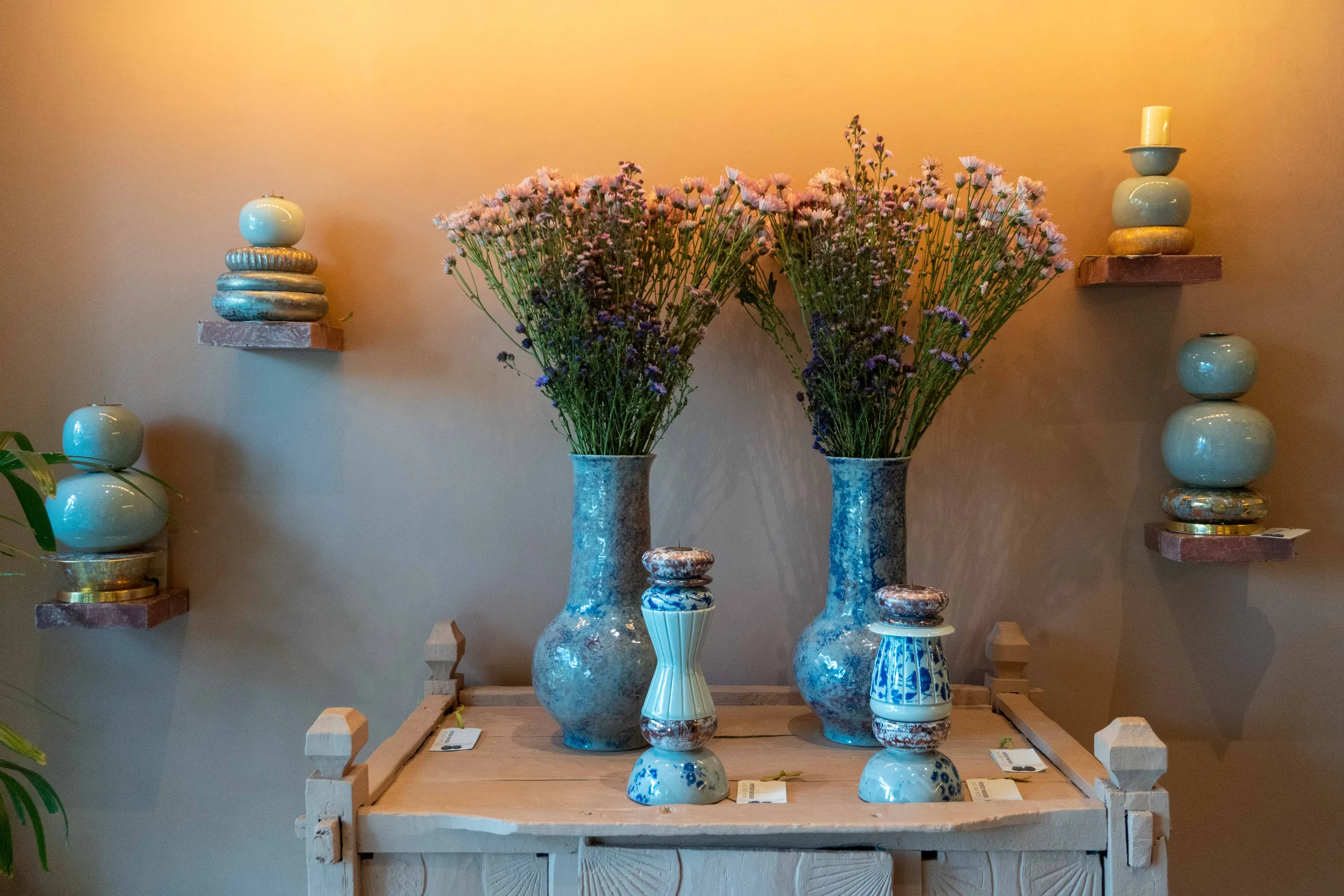 Blue ceramic vases with dried flowers on a console