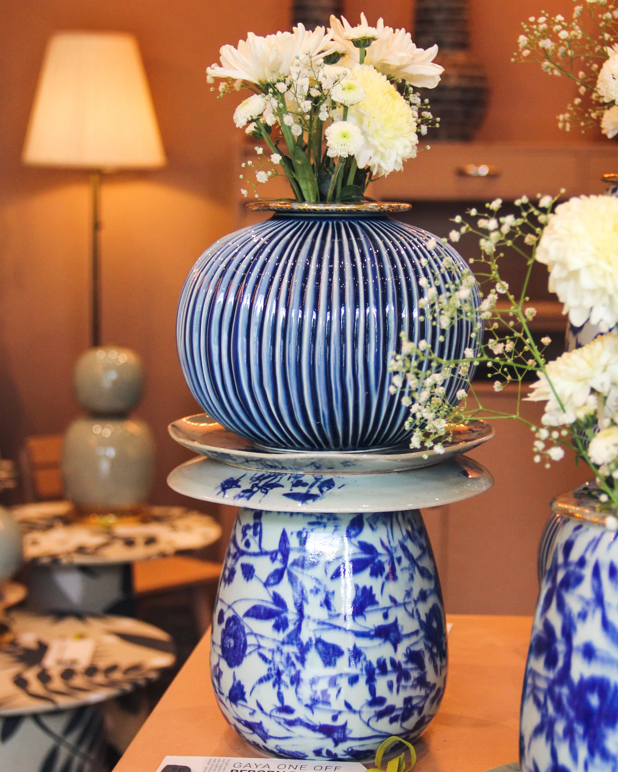 Stacked blue-and-white patterned ceramic vases holding white flowers