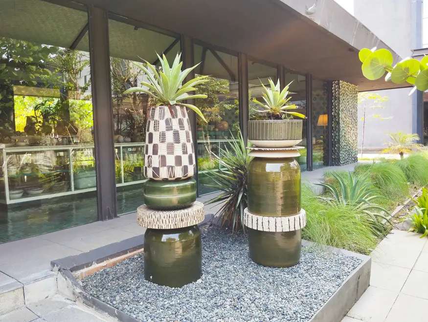 Outdoor ceramic display with planters and tropical greenery